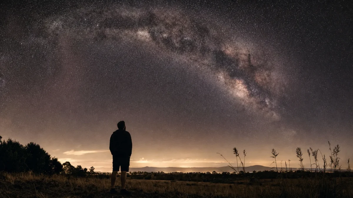 Osservatore sotto un cielo stellato con la Via Lattea